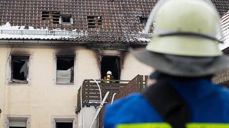 Ein Feuerwehrmann schaut auf das ausgebrannte Haus. Foto: Tobias Köpplinger