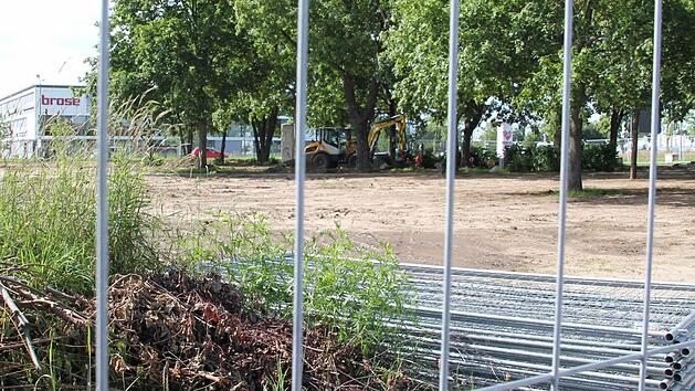 Derzeit wird der Eingang zur Gartenstadt entlang der Memmelsdorfer Stra&szlig;e umgestaltet: Das Gel&auml;nde ist &ouml;kologische Ausgleichsfl&auml;che. Die Firma Brose will das Areal mit Natursteinen, Pflanzen und weiteren B&auml;umen aufwerten. P&uuml;nktlich zur Er&ouml;ffnung des neuen Firmen-Standorts an der Breitenau (im Hintergrund) soll das Gel&auml;nde fertig sein.  Foto: Sebastian Martin
