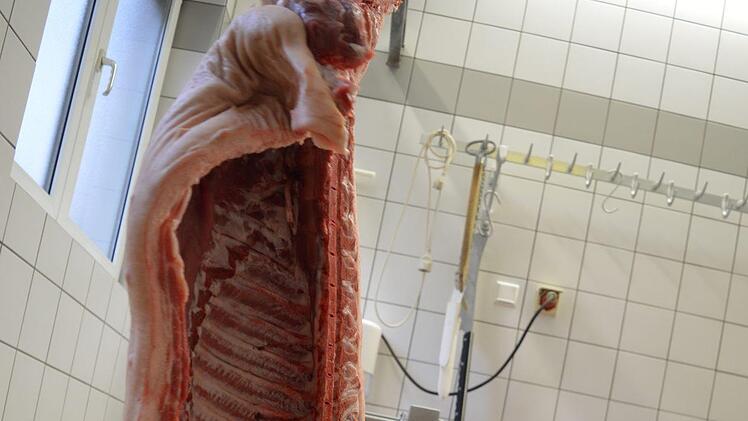 Meusel trennt den Kopf von der aufgehängte Schweinehälfte Foto: Ronald Heck