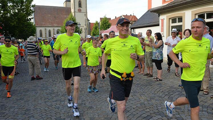 Los geht's: Die Läufergruppe startete in Haßfurt. Landrat Wilhelm Schneider (Zweiter von rechts) war auf den ersten Kilometern dabei. Rechts ist Oliver Fesser, der Hauptorganisator der 1267 Kilometer langen Tour. Radfahrer und Wohnmobile folgten den Läufern.   Fotos: Ronald Rinklef