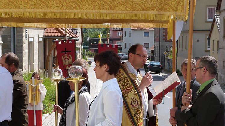 In Prozession zogen die Gläubigen von der Kirche St. Kilian aus hin zu den Altären, die im Dorf aufgebaut waren. Unter dem "Himmel" Pfarrer Kurt Wolf mit der Monstranz.