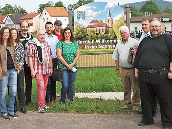 Die Vertreter der Schneyer Vereine mit der Stadträtin Elke Werner (links neben der Tafel) als Sprecherin sowie die Sponsoren freuen sich zusammen mit dem Bürgermeister Andreas Hügerich über die gelungenen neuen Ortstafeln, die die beiden Pfarrer Tanja Vincent (Zweite von links) und Roland Neher (Vieter von links) segneten. Foto: Alfred Thieret