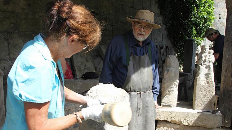 Aus dem Sandsteinquader soll in den kommenden zwei Wochen ein "Nimrod" entstehen. Brigitte Bühler ist zum elften Mal bei der Sandsteinwerkstatt dabei. Akademischer Bildhauer Heinrich Schreiber gibt den zehn Schülern Tipps. Foto: Friedwald Schedel