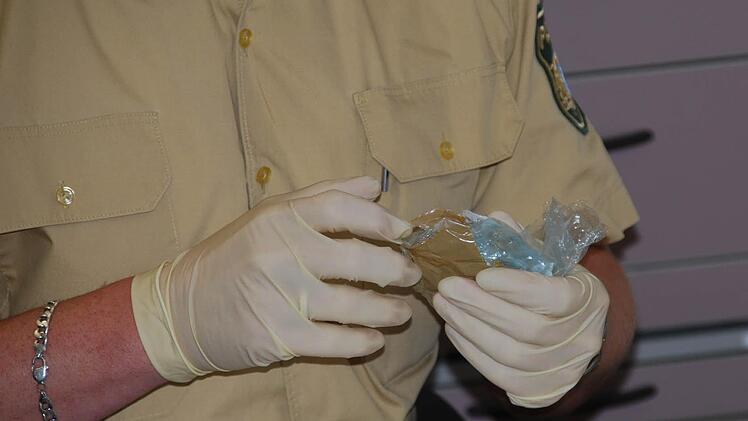 Mit Handschuhen stellen die Beamten die Substanzen sicher. Foto: Polizei