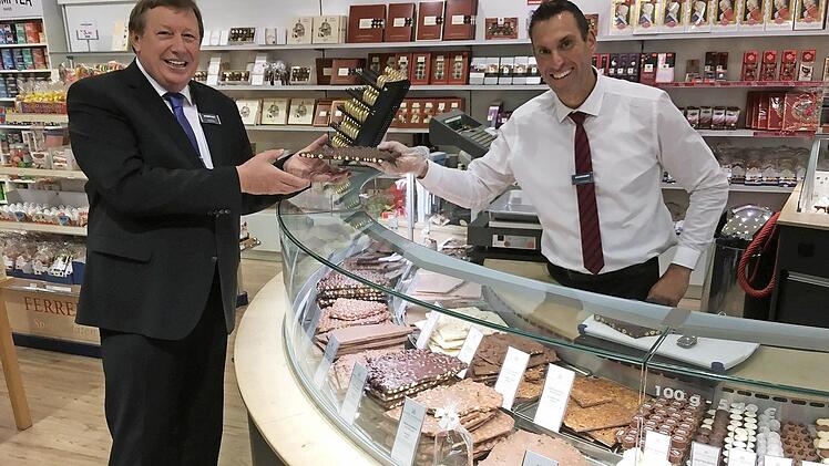 Alfons Distler lässt sich von Mitarbeiter Thomas Goppert ein Stück Schokolade geben. Die Confiserie wurde zuletzt vergrößert.  Foto: M. Memmel