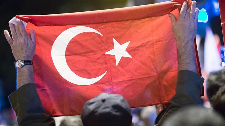 Ein Mann hält bei einer Demonstration in der Folge eines Putschversuchs von Teilen des türkischen Militärs vor dem türkischen Generalkonsulat in Hamburg eine türkische Fahne.  Foto: Paul Weidenbaum, dpa