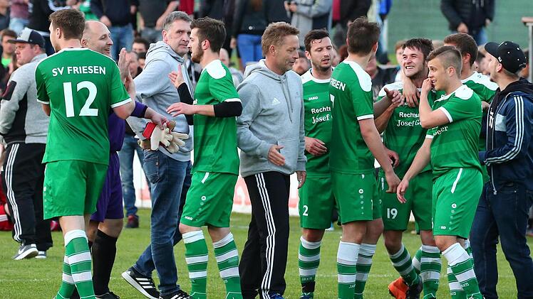 Die Freude bei den Spielern des SV Friesen und Trainer Peter Reichel (Mitte) nach dem Schlusspfiff war groß. Nach dem 2:1 gegen den BSC Saas Bayreuth steht die Tür zur Landesliga weit offen. Foto: Heinrich Weiß