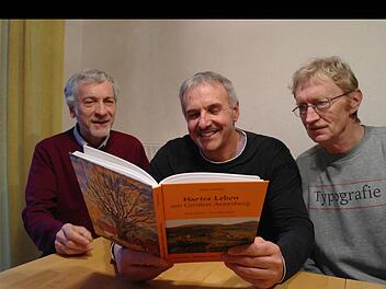 Der erste Blick ins druckfrische Buch "Hartes Leben am Großen Auersberg" - das Ergebnis stellt Guido Sauer, Walter Kömpel und Karl Hahn zufrieden. Foto: Stephanie Elm