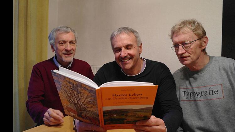 Der erste Blick ins druckfrische Buch "Hartes Leben am Großen Auersberg" - das Ergebnis stellt Guido Sauer, Walter Kömpel und Karl Hahn zufrieden. Foto: Stephanie Elm