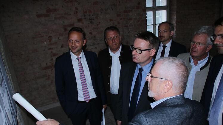 Architekt Hans-Hermann Drenske (vorne) erklärt die Sanierung der Spinnstuben. Mit dabei (von links) Bürgermeister Robert Bosch, Kulmbachs OB Henry Schramm, Staatssekretär Josef Zellmeier, stellvertretender Landrat Jörg Kunstmann, MdL Ludwig von Lerchenfeld, MdL Martin Schöffel. Foto: Jürgen Gärtner