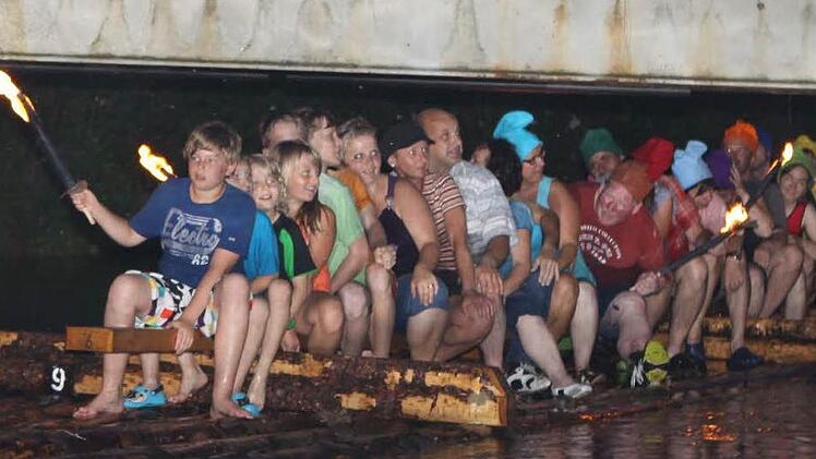 Die "Beifahrer" der Flößer liefen im Fackelschein in Wallenfels ein. Fotos: Michael Wunder