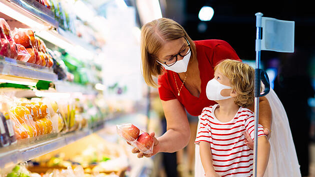 Mother and child buying fruit in supermarket.