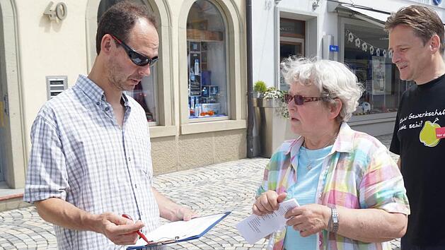 Ein Passant unterschreibt: Um Bundeskanzlerin Angela Merkel auf den Handlungsbedarf aufmerksam zu machen, soll eine Liste mit Unterschriften nach Berlin geschickt werden. Die Unterschrift nehmen Ilse Scholz und Jens-Uwe Frosch (von links) entgegen.  Fotos: Peter Schmieder