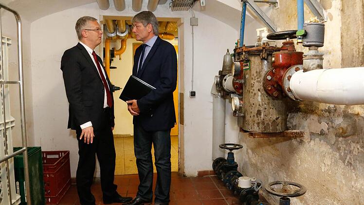 JVA-Leiter Ulrich Mann (links) und MdL Heinrich Rudrof, Vorsitzender des Anstaltsbeirates, im Heizungskeller. Die Versorgungsanlagen sind selbstverständlich noch funktionsfähig, aber doch schon deutlich in die Jahre gekommen.  Fotos: Matthias Hoch