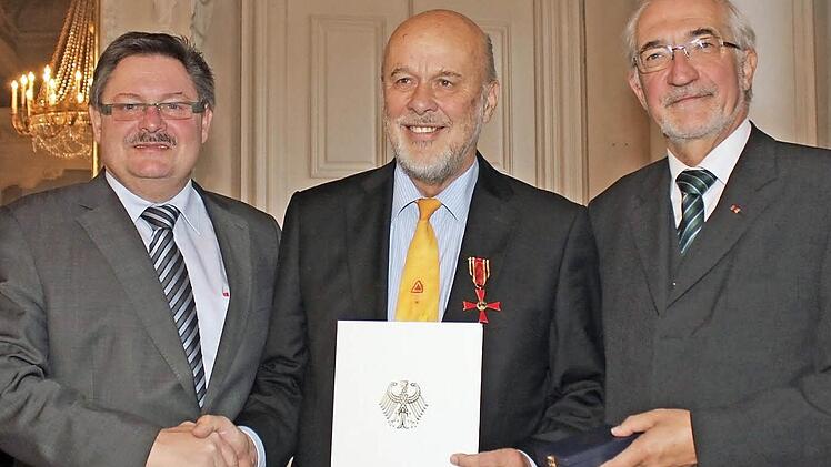 Innenstaatssekretär Gerhard Eck (links) und Regierungspräsident Paul Beinhofer (rechts) überreichten Michael Peter am Donnerstag in Würzburg Urkunde und Verdienstkreuz der Bundesrepublik.  Foto: Hardenacke
