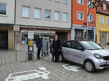 Geschäftsführer Jürgen Fiedler (l.), Bürgermeisterin Christiane Meyer und Landrat Hermann Ulm betanken das Elektrofahrzeug der Stadtwerke. Foto: PR