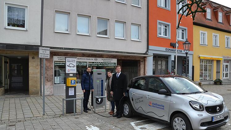 Geschäftsführer Jürgen Fiedler (l.), Bürgermeisterin Christiane Meyer und Landrat Hermann Ulm betanken das Elektrofahrzeug der Stadtwerke. Foto: PR