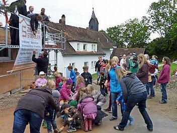 So viele Süßigkeiten dürfte es öfters regnen. Die Kinder freuten sich und machten beim Richtfest zur Kiga-Erweiterung fleißig mit. Foto: K,-H. Hofmann