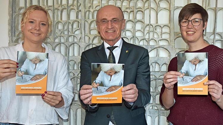Pr&auml;sentieren den neuen &bdquo;Wegweiser Demenz&ldquo; f&uuml;r den Landkreis Ha&szlig;berge (v.l.): Vera Ksinski, Pflegenetzwerk Ha&szlig;berge, Landrat Wilhelm Schneider und Katrin Jung, Gerontopsychiatrische Vernetzung Main-Rh&ouml;n.