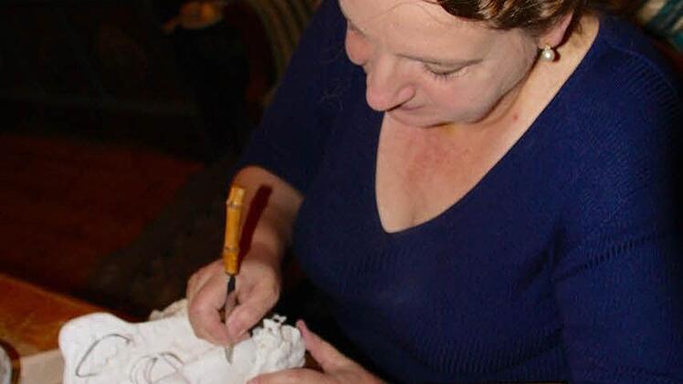 Beate Pohlus bei der Arbeit Unten rechts Masken, die die Künstlerin im Lauf der Jahre anfertigte.