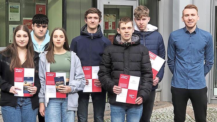 Die Erstplatzierten Fiona Scholl, Muzafer Zekjiroski, Jule Gick (v. l.) vom Team „Börsenprofis-187“ sowie Samuel Kalkus, Christof Morgenroth, Philipp Ott (4., 5. und 6. v.l.) vom Team „ID31319111615“, das auf Platz fünf landete, freuten sich über ...