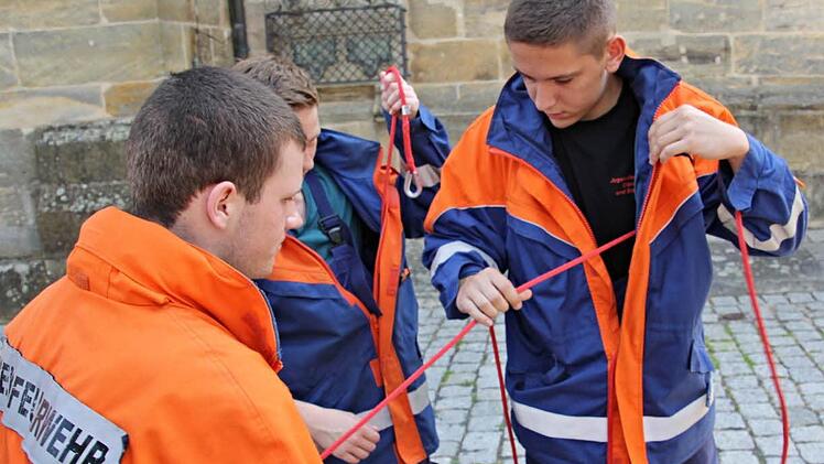 Eine kniffelige Angelegenheit unter Zeitdruck eine Rettungsleine durch Jackenarme und Hosenbeine eines Einsatzanzuges zu führen.