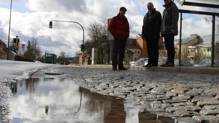 Drei Männer am See: Die Straßenentwässerung spielt bei der Sanierung der B 303 in Stadtsteinach eine wichtige Rolle, wie (von links) Bürgermeister Roland Wolfrum sowie Siegfried Beck und Jan Oertel vom Straßenbauamt betonen. Das Bild entstand in Höhe der Bushaltestelle an der Fachklinik. Foto: Matthias Beetz