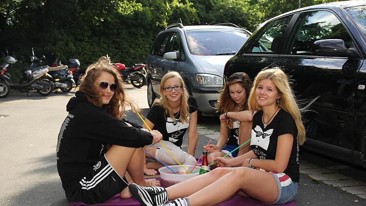 Katharia Holzapfel, Sarah Wölfel, Anna Butzbacher und Hannah Niewerth lassen sich auf dem Parkplatz ihre Erdbeerbowle schmecken. Foto: Andreas Brand