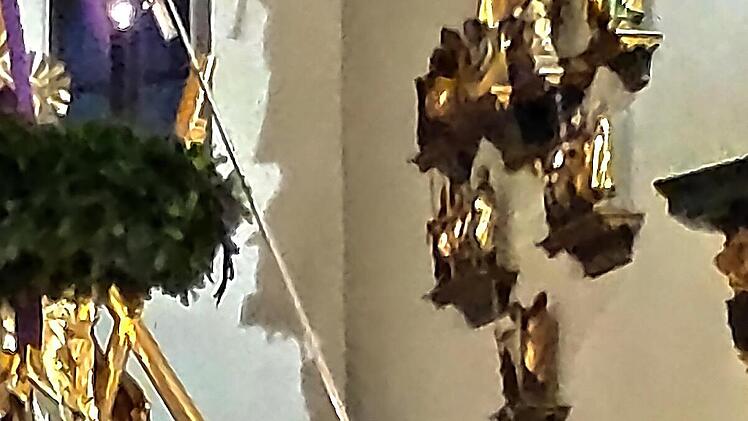 Pfarrer Kilian Kemmer entz&uuml;ndet eine Kerze auf dem Kranz.