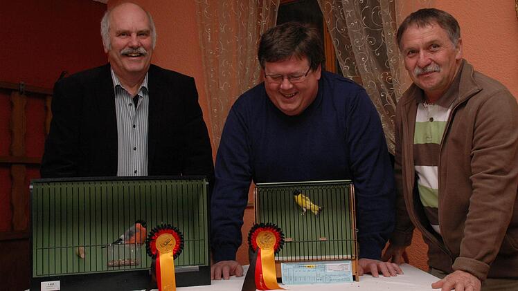 Sechs Deutsche Meistertitel haben Roland Hehn und Ralf Dotzel (v. l.) bei den 65. Deutschen Meisterschaften in Bad Salzuflen mit ihren Vögel geholt. Zu ihrem Erfolg gratulierte der stellvertretende Vereinsvorsitzende der Vogelfreunde Bad Kissingen, Bruno Kirchner (rechts).Foto: Peter Klopf