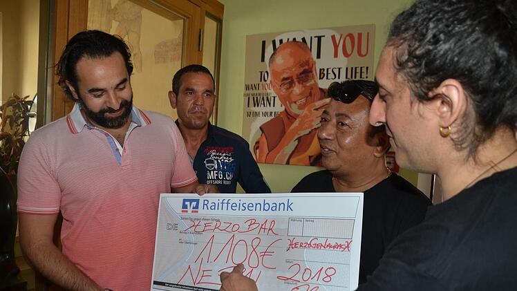 Alberto Parmigiani (rechts) erklärt vor dem Plakat des Dalai Lama die besondere Bewandnis der Zahl 108 für Buddhisten. Aber auch für Wirt Sami Alijaj (links) hat der der Betrag eine Bedeutung: Ein 11.08. war einst sein erster Tag in Herzogenaurach. Mit im Bild Helfer Sadi und Klangschalenmeister Santa Ratna Shakya, mit dem Alberto zurzeit auf Tournee geht. Nächste Station ist Frankreich.  Foto: Bernhard Panzer