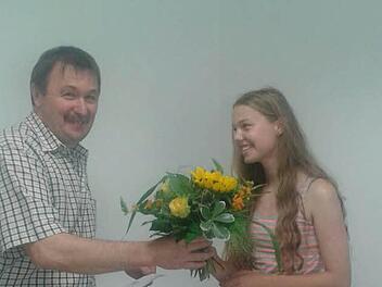 Riedenbergs Bürgermeister Roland Römmelt überreicht Franziska Wolf Blumen. Sie legte ihren Qualifizierten Abschluss als Schulbeste ab.Foto: Evelyn Schneider