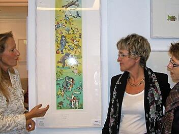 Galeristin Elisabeth Hirnickel (links) erklärt den Gästen vom Bad Kissinger Frauenring, Vorsitzende Birgit Fischer (Mitte) und Barbara Thiele, die phantasievollen Bilder des Künstlers Janosch Foto: Karin Reinshagen