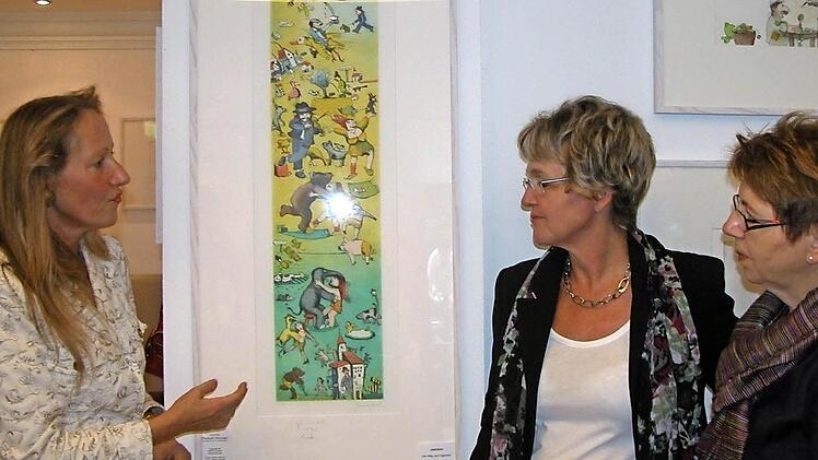 Galeristin Elisabeth Hirnickel (links) erklärt den Gästen vom Bad Kissinger Frauenring, Vorsitzende Birgit Fischer (Mitte) und Barbara Thiele, die phantasievollen Bilder des Künstlers Janosch Foto: Karin Reinshagen