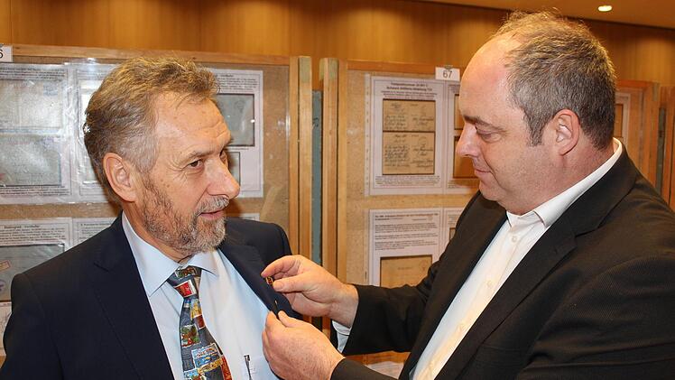 Oliver Bauer (rechts), Geschäftsführer des Bezirksverbandes Unterfranken des Volksbundes Deutsche Kriegsgräberfürsorge, überreicht Erich Fries die Bronzene Ehrennadel des Verbandes.Paul Ziegler