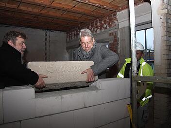Bürgermeister Horst Rehder und Architekt Mario Bodem heben den Grundstein an seinen neuen Platz.