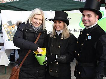 Die Krankenschwester Nicole Sperber unterstützt gerne die Aktion der der Kaminkehrer und greift in die Lose, die von den beiden Kaminkehrern Ramona Brehm und Falk Zitzmann verkauft werden. Foto: Michael Stelzner