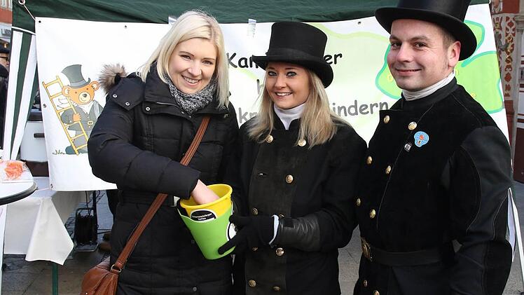 Die Krankenschwester Nicole Sperber unterstützt gerne die Aktion der der Kaminkehrer und greift in die Lose, die von den beiden Kaminkehrern Ramona Brehm und Falk Zitzmann verkauft werden. Foto: Michael Stelzner