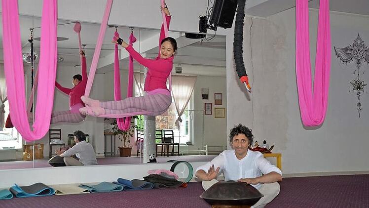 Alberto Parmigiani trommelt zu der Yoga-Übung seiner Frau Tingting Huang auf der Hand Pan. Aus dem einstigen Schlagzeug-und Percussionstudio - da standen schon mal gleichzeitig 25 Sets - und einem Zumba-Tanzraum ist jetzt ein Yoga-Studio mit einem neuen Konzept und viel Wärme und Liebe geworden, wie der Herzogenauracher mit dem italienischen Blut verrät.  Foto: Bernhard Panzer