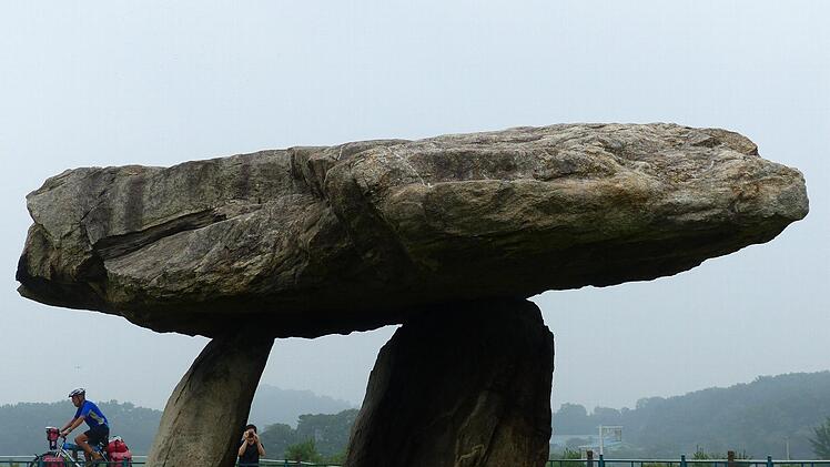 Erinnern an Steinblöcke in der Bretagne oder Südengland: Zwei- bis dreitausend Jahre alte Dolmen auf der koreanischen Halbinsel. Im Hintergrund radelt Dietmar Roth.Foto: Manfred Wagner