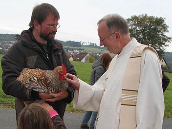 Martin Brand hat einen stolzen Hahn zur Segnung mitgebracht. Unser Bild zeigt das Tier und seinen Besitzer mit Dekan Hans Roppelt. Fotos: Sonja Adam