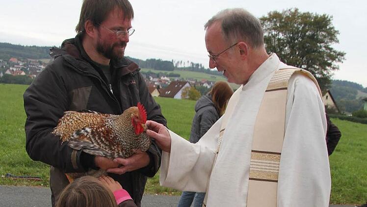 Martin Brand hat einen stolzen Hahn zur Segnung mitgebracht. Unser Bild zeigt das Tier und seinen Besitzer mit Dekan Hans Roppelt. Fotos: Sonja Adam