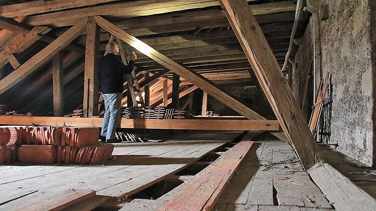 Pater Markus Reis schaut sich den Dachstuhl im Nordflügel der Stadtpfarrkirche an. Vermutlich im 19. Jahrhundert wurden dort Renovierungsarbeiten durchgeführt, die jetzt statische Probleme machen. Foto: Heike Beudert