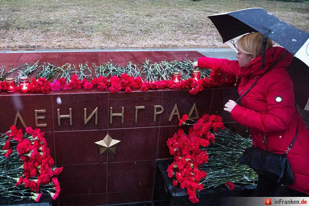 Eine Frau zündet eine Kerze an für die Opfer der Explosion in einer U-Bahn in St.Petersburg