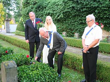 Johann Stromer, Vorsitzender des VdK Höchstadt (Mitte), legte an den Gedenksteinen der Opfer des Ersten Weltkriegs Rosen nieder. Foto: Evi Seeger