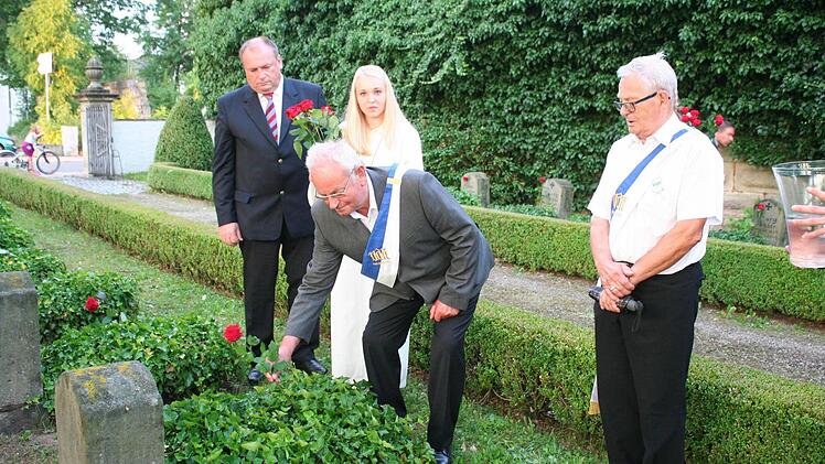 Johann Stromer, Vorsitzender des VdK Höchstadt (Mitte), legte an den Gedenksteinen der Opfer des Ersten Weltkriegs Rosen nieder. Foto: Evi Seeger