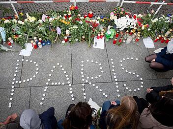 Menschen trauern am 14.11.2015 vor der französischen Botschaft am Brandenburger Tor in Berlin nach den Attentaten in Paris. Foto: Kay Nietfeld/dpa