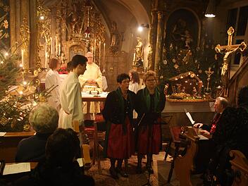 Die Christmette in St. Moritz wurde von Ottilia Heid, Petra Geisler und Otto Rehm musikalisch ausgestaltet. In seiner Predigt zog Pfarrer Herbert Hautmann (hinten) einen Vergleich zwischen seinem eigenen Schicksal und den aktuellen Flüchtlingen. Foto: Franz Galster