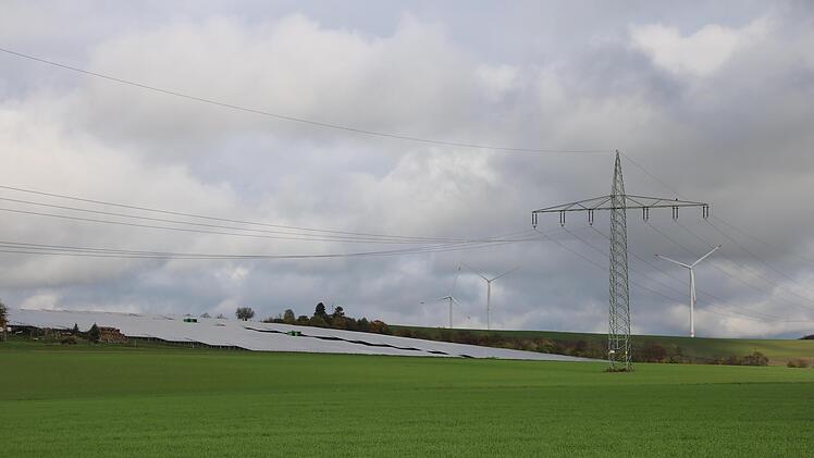 Rund um den Aussichtspunkt "Knückelein" in Ramsthal stehen Freiflächen-PV-Anlagen, Windräder und Stromtrassen eng beieinander.
