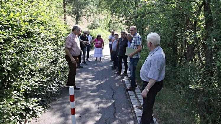 Dieser Weg, zwischen dem Lützeleberner- und Hans-Merkl-Weg im Baugebiet Mannlehen, soll ausgebessert werden. Damit soll eine teilweise Verbreiterung entlang des Grundstücks (links) erfolgen, wie Bürgermeister Jürgen Hennemann (links) und Bauamtsleiter Martin Lang (2. von rechts) erläuterten. Foto: Helmut Will